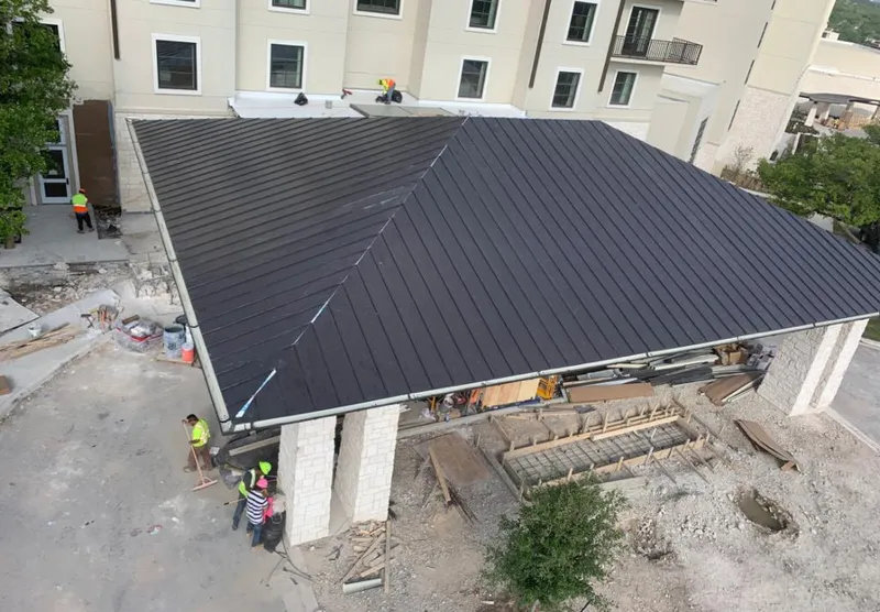 Metal roofing installation team working on a commercial building in Waller